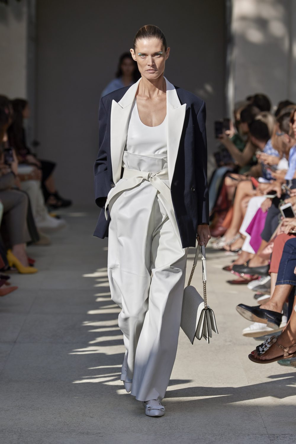 calça branca clochard com blazer marinho e bolsa branca semana de moda milão